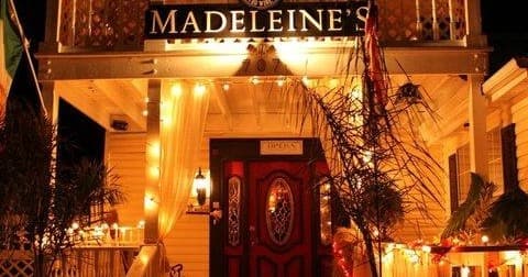 Historic inn entrance lit with warm lights on porch at night