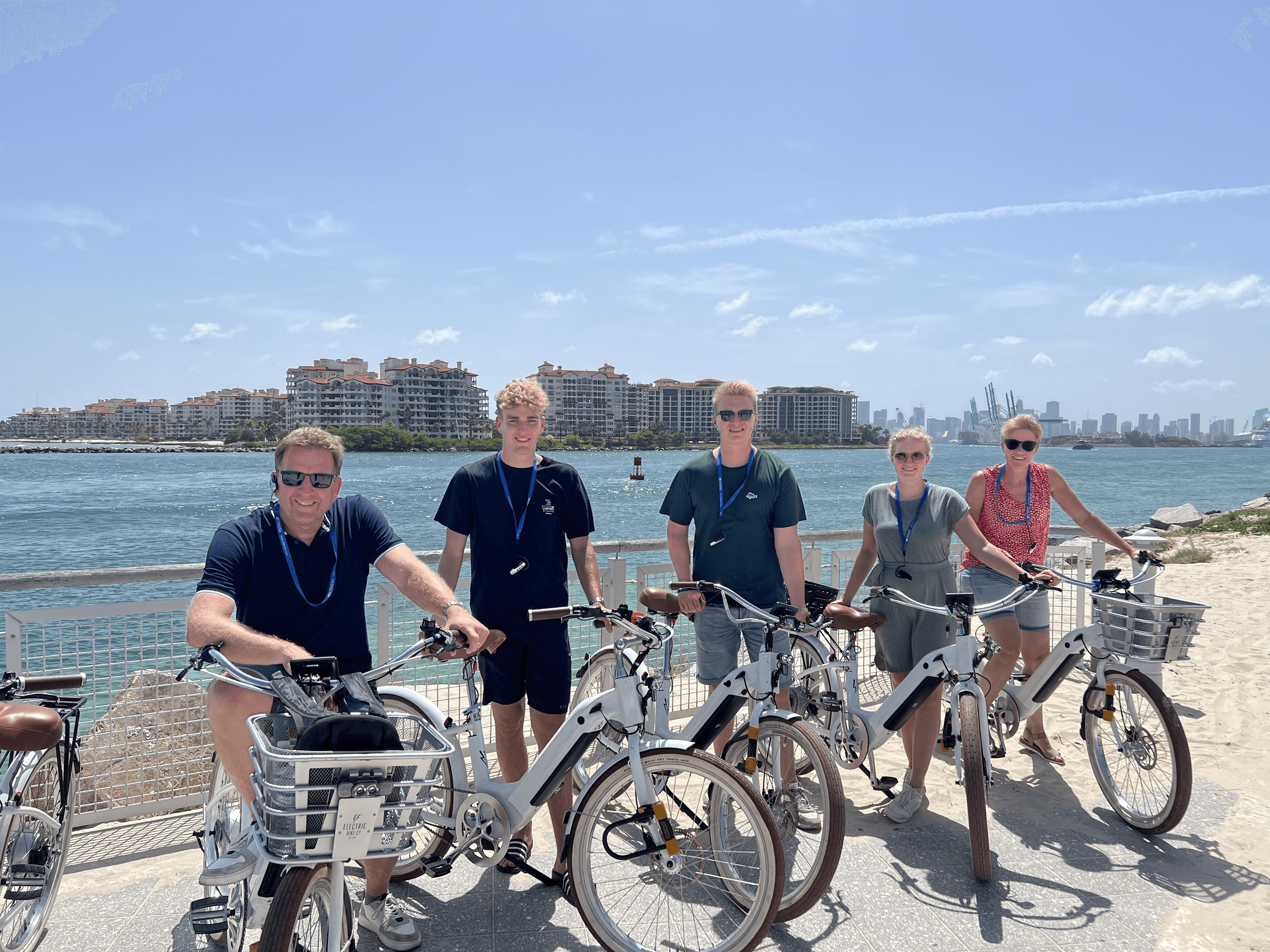 Trikke tour group posing with coastal skyline in background