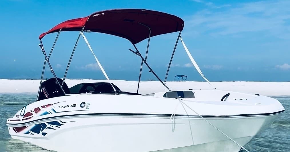 White bow boat with red canopy on turquoise water, day cruise