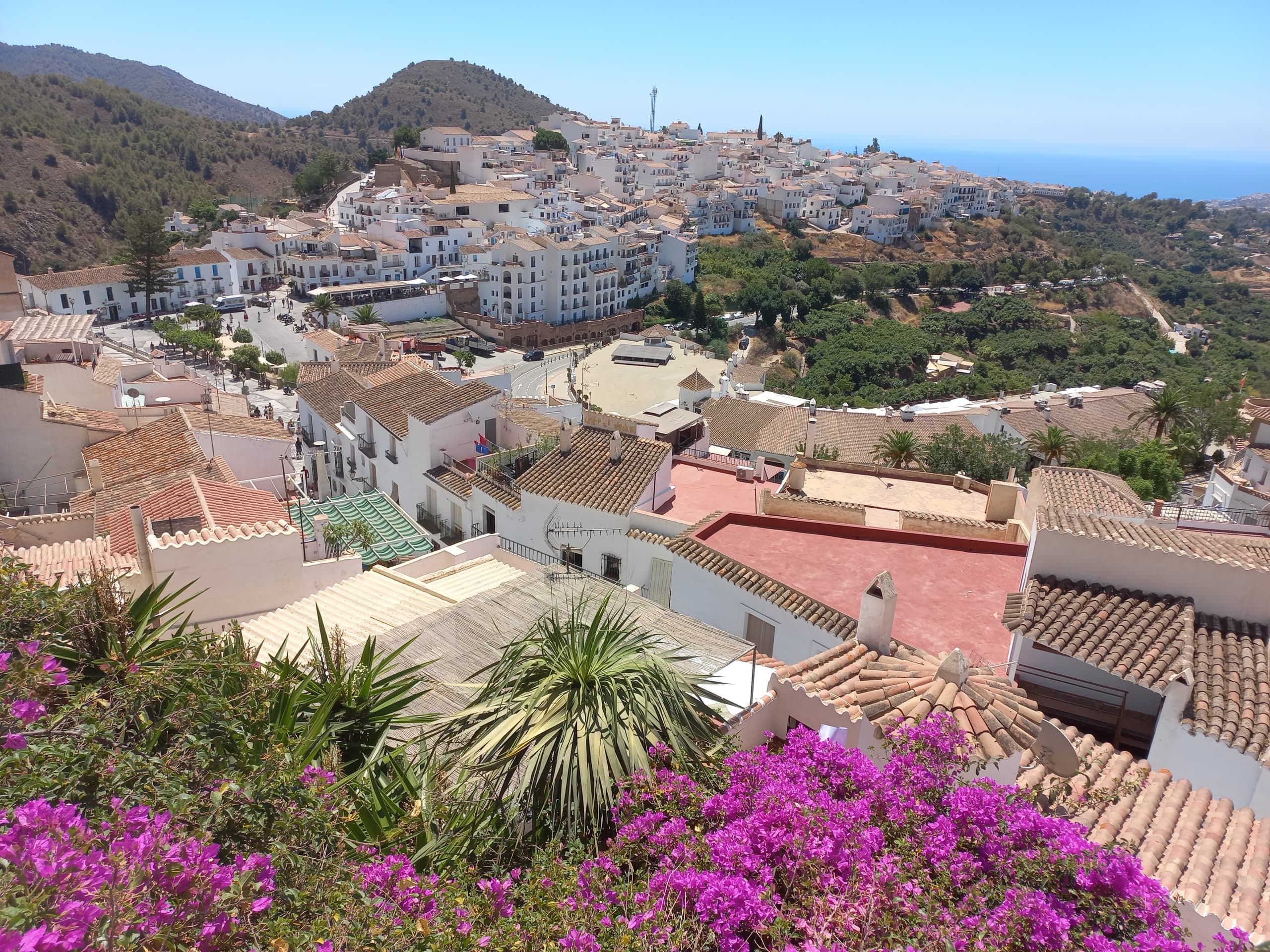 Whitewashed Andalusian village with bougainvillea and sea views