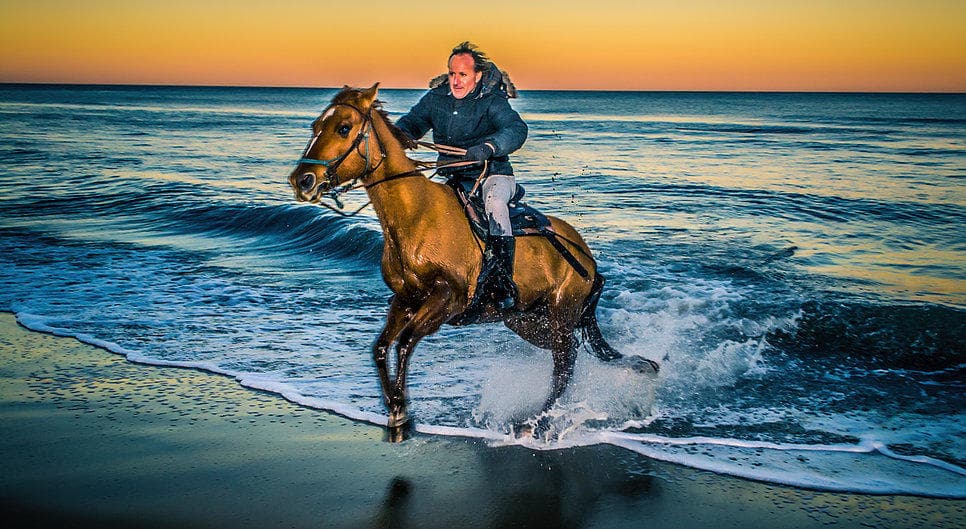 Galloping horse splashing through ocean waves at Virginia Beach
