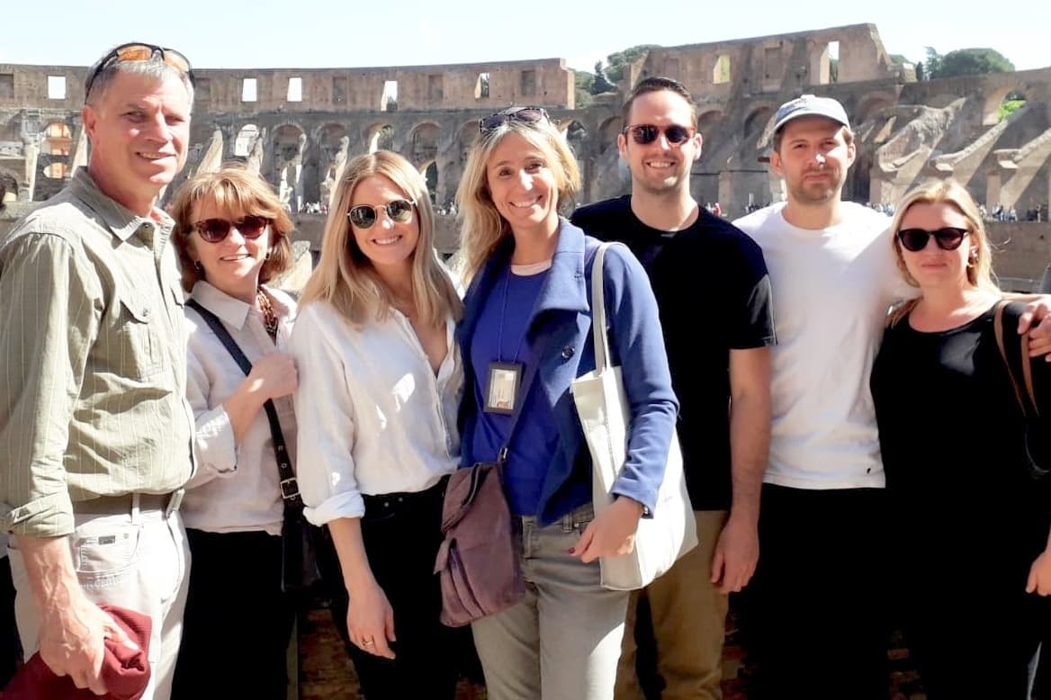 Tour group posing in front of the Colosseum arches during Rome tour