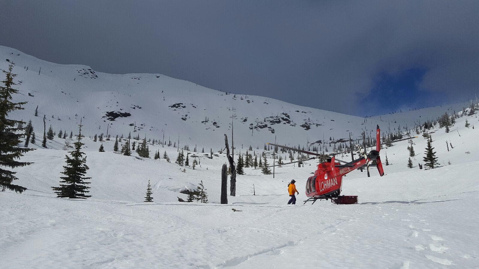 Helicopter and guide team on snowy alpine ridgeline