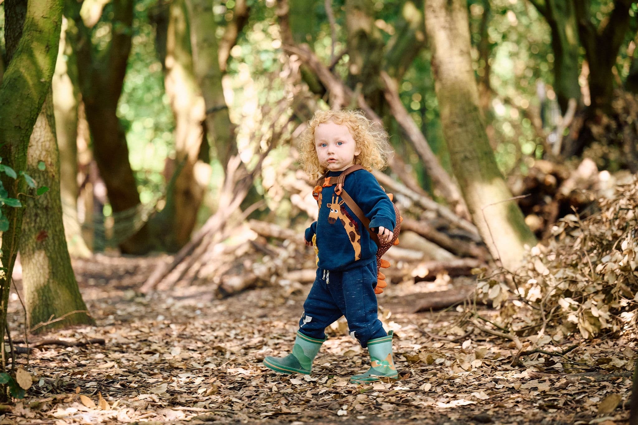Toddler exploring forest trail among trees at Betteshanger Park