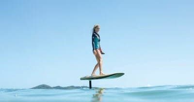 Stand-up hydrofoil rider cruising calm blue coastal waters