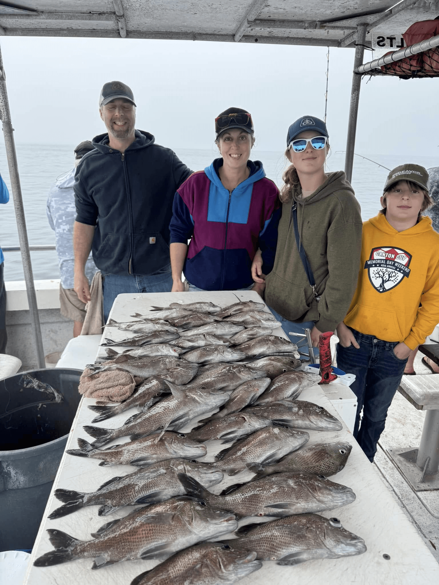 Family and friends showing large mixed catch on charter boat