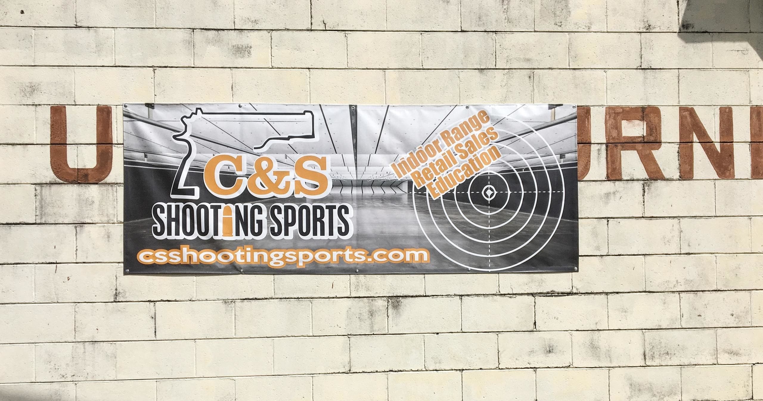 CSShootingSports facility banner on brick wall at shooting range