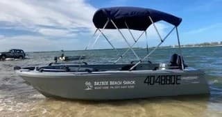 Small hire skiff anchored in shallow bay for beach trips