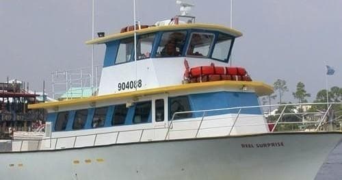 Two-deck charter vessel moored near pier, coastal sightseeing