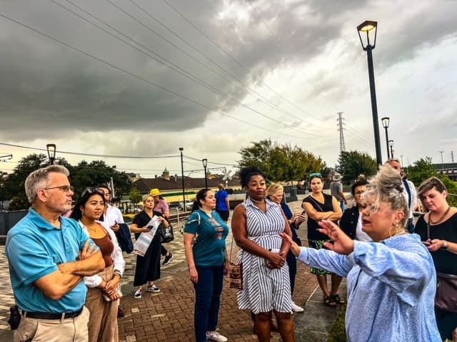 Guided walking tour group outdoors under dramatic stormy sky