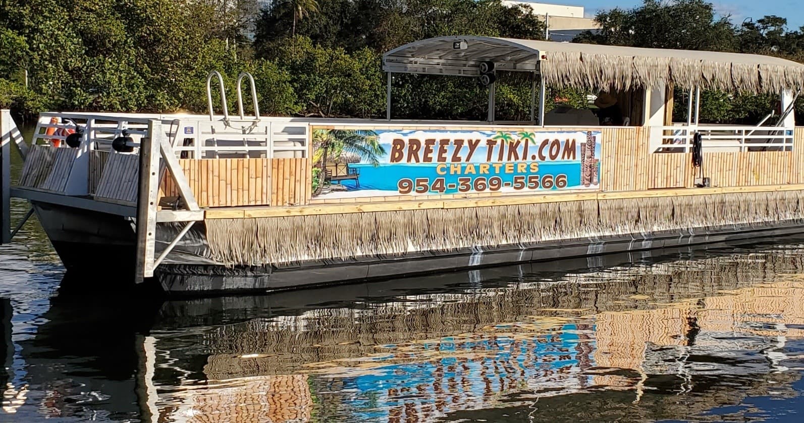 BreezyTiki pontoon on reflective river shore during daylight