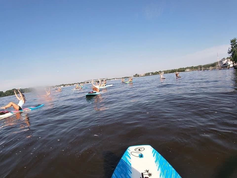 Paddleboard POV with paddlers gliding across calm water