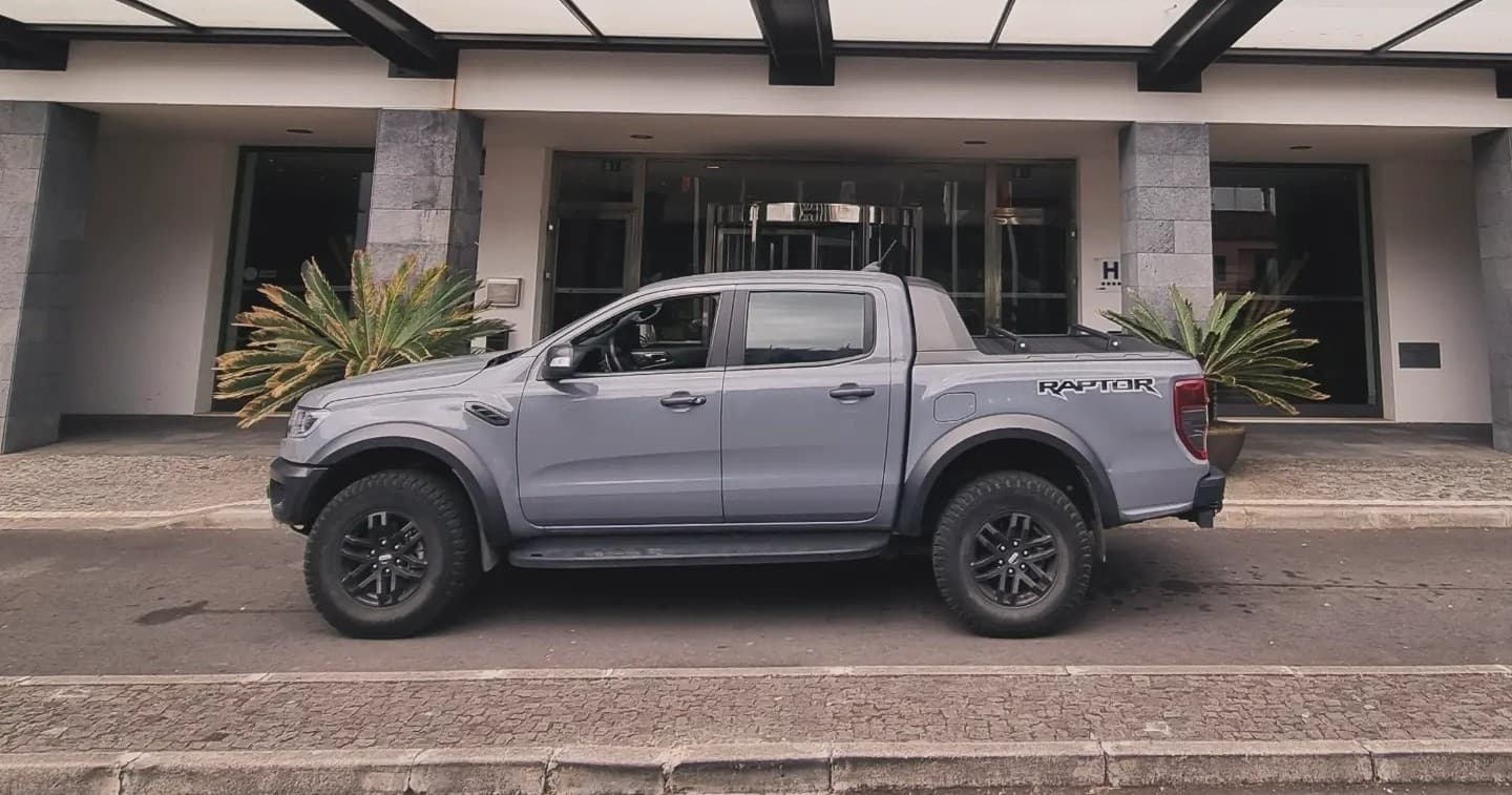 Grey pickup truck parked in front of hotel, minimal outdoor context
