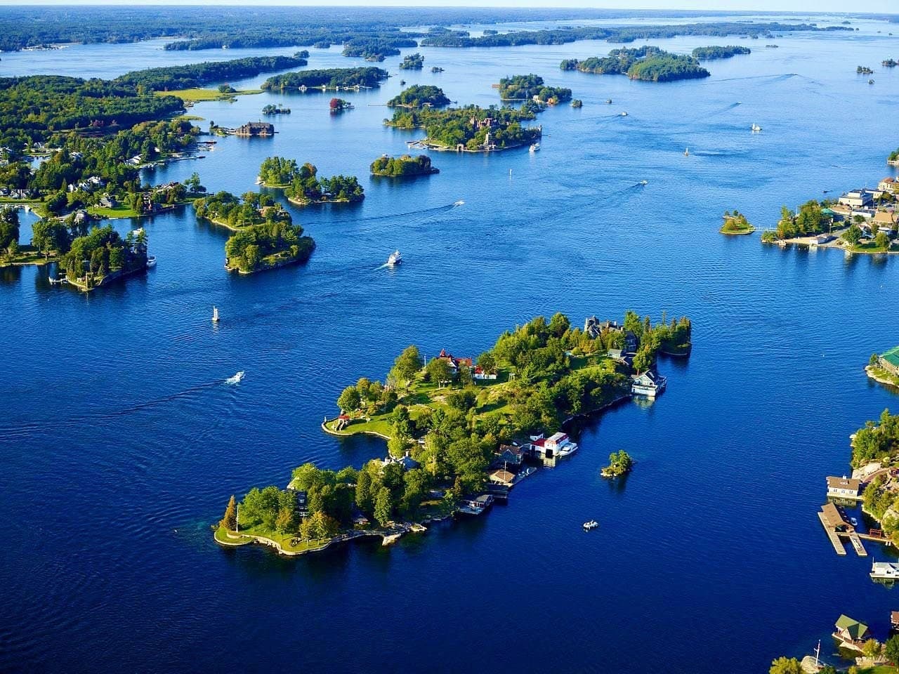 Aerial view of scattered Thousand Islands over clear blue St Lawrence waters