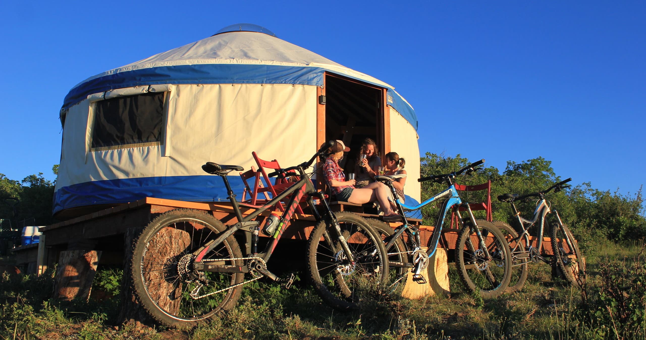 Glamping yurt with parked mountain bikes under blue sky