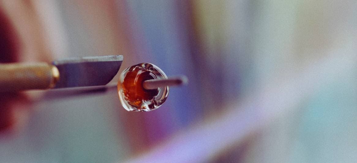 Close-up molten glass being shaped in a studio torch