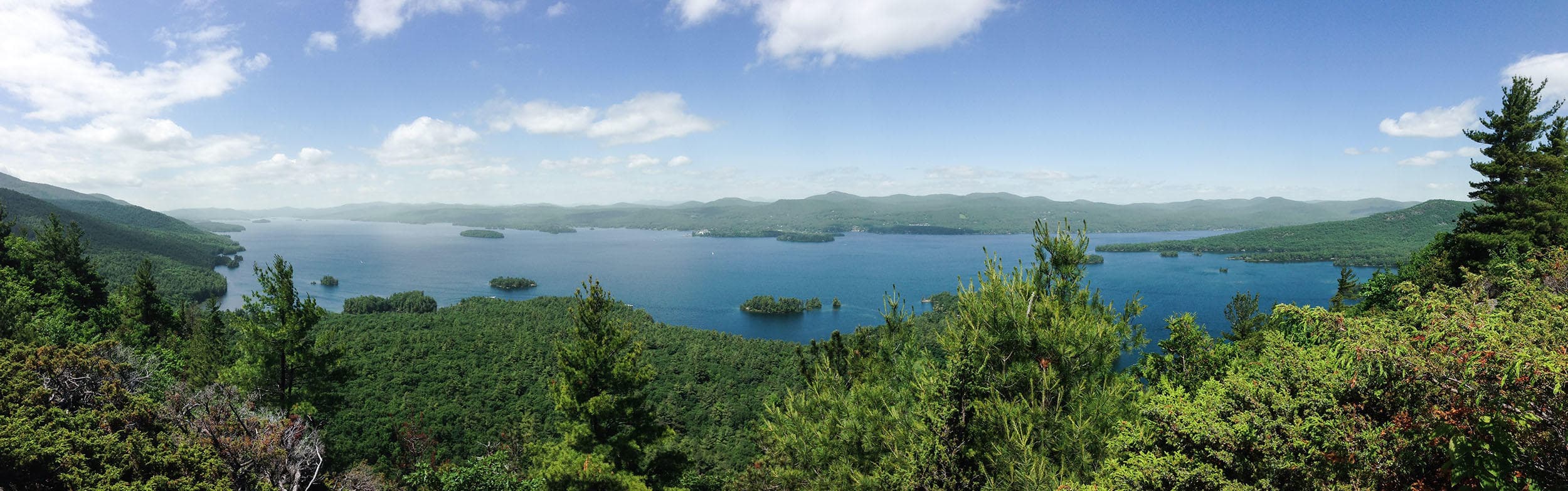 Panoramic forested lake with island-studded shoreline view
