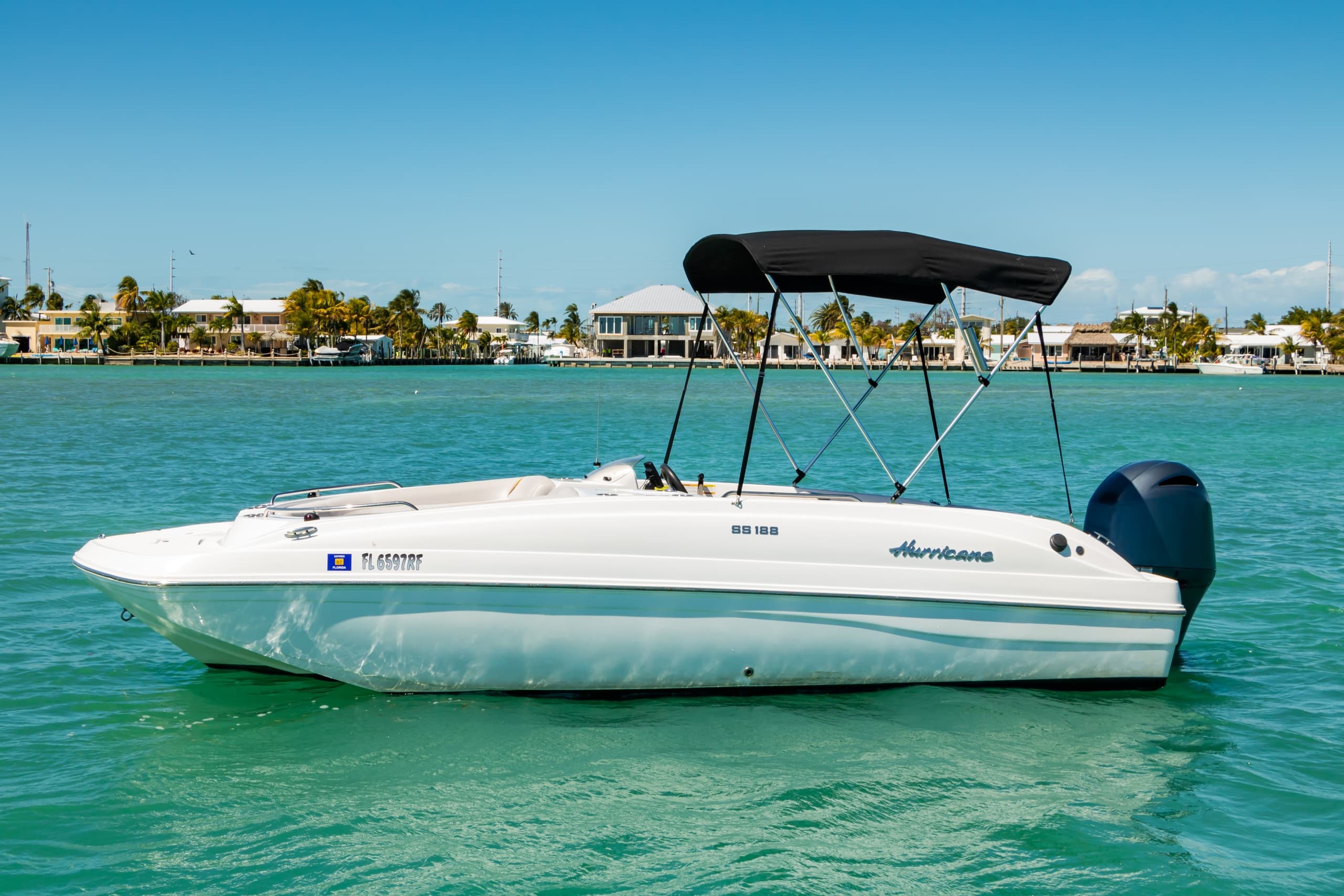 White powerboat cruising turquoise bay with sunny skyline