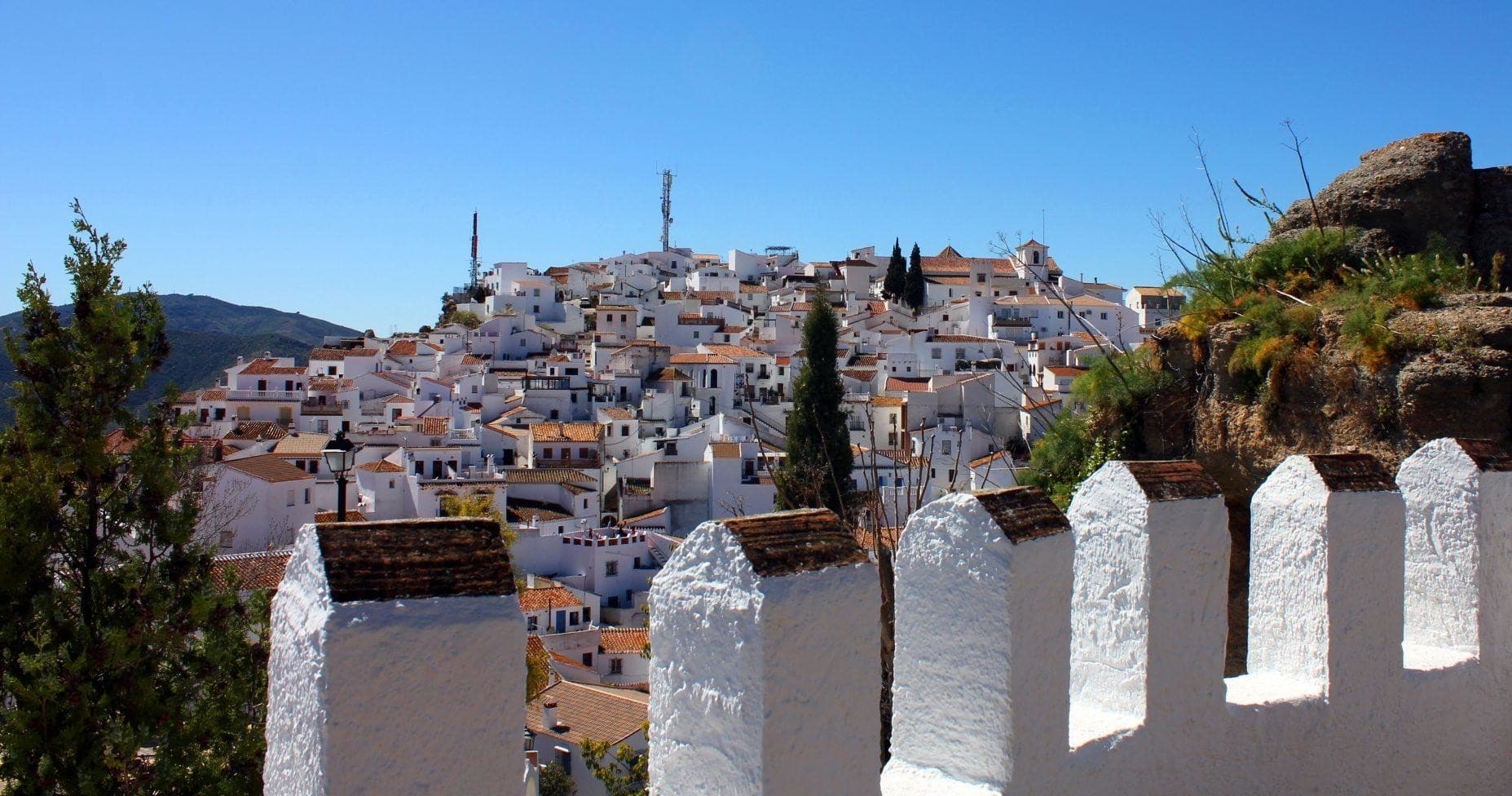 White hilltop village vista with fortress wall, Andalusian scenery