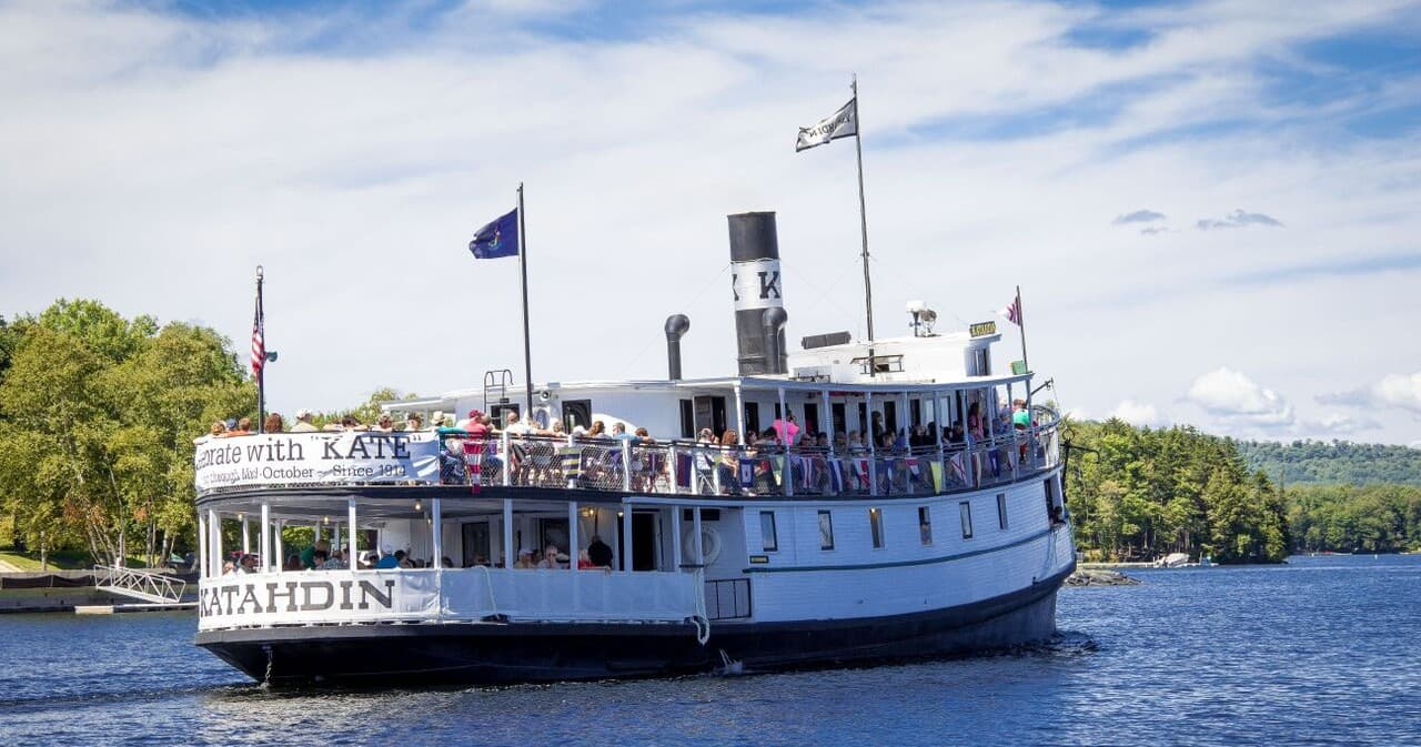 Crowded sightseeing steamer cruising lake with passengers aboard