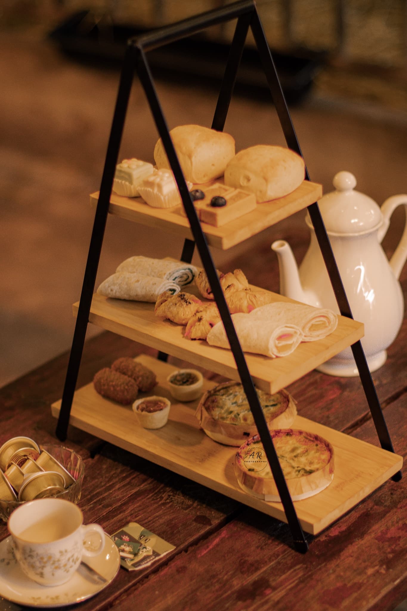 Afternoon tea and pastries on indoor tiered stand at cafe
