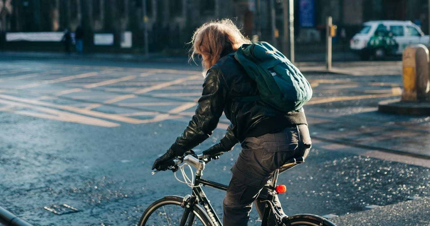 Urban cyclist riding through wet city streets, commuting in rain