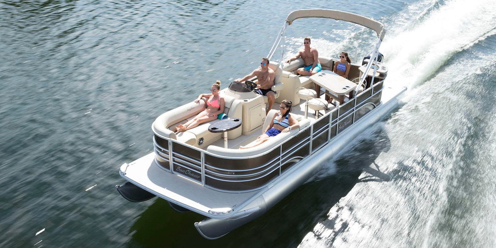 Pontoon boat cruising coastal waters with passengers enjoying ride