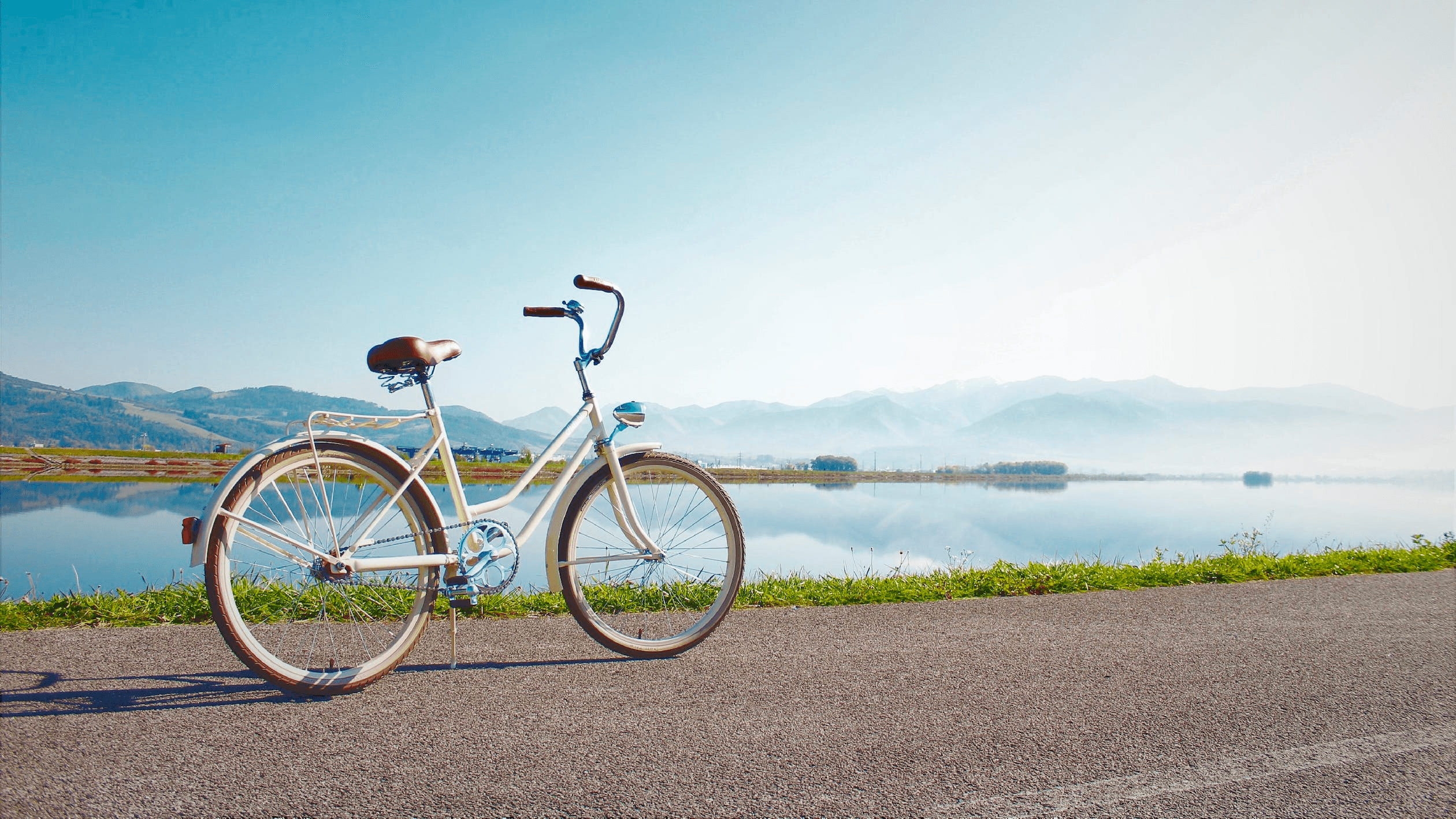 Road bike parked by lakeside with mountains, scenic cycling