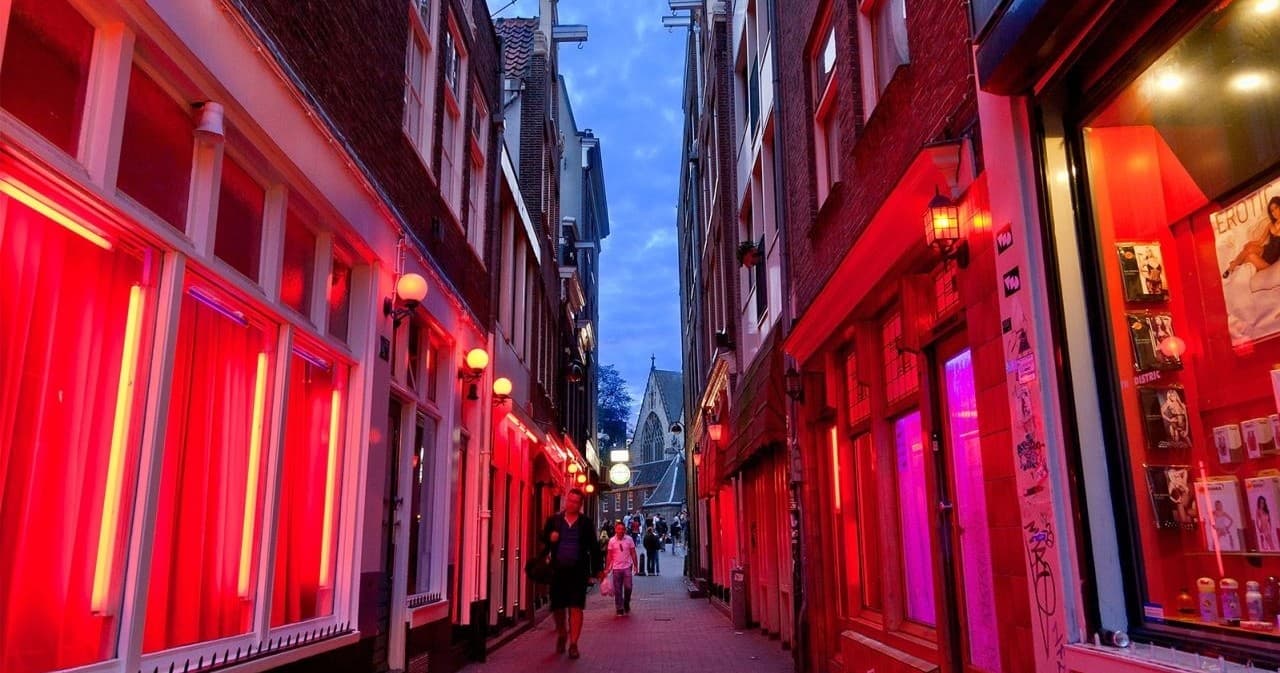 Red-lit Amsterdam street in Red Light District evening walk