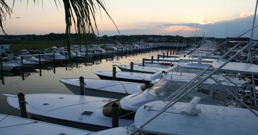 Marina at sunset with moored boats and calm harbor water