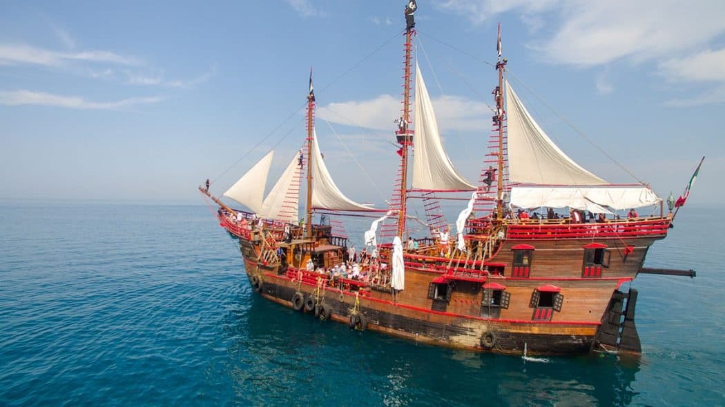 Traditional tall-ship sailing on calm sea, sunset cruise