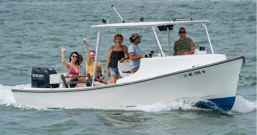 Small charter boat with passengers cruising coastal waters
