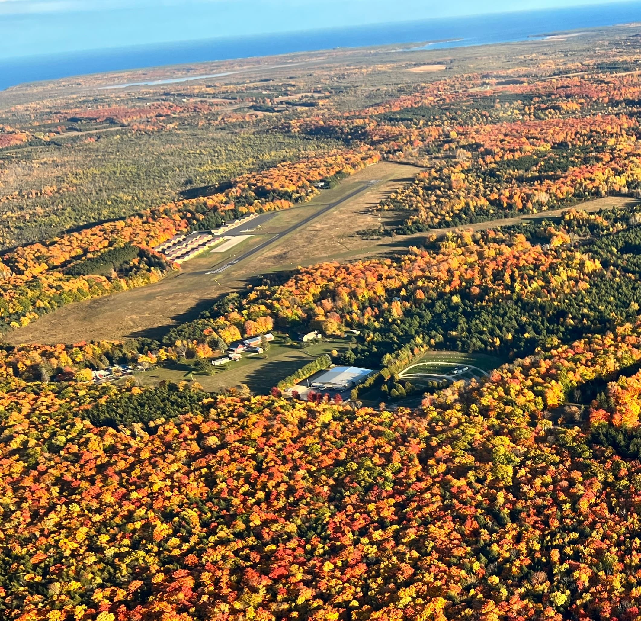 Aerial view of autumn forest and lake shoreline scenic flight