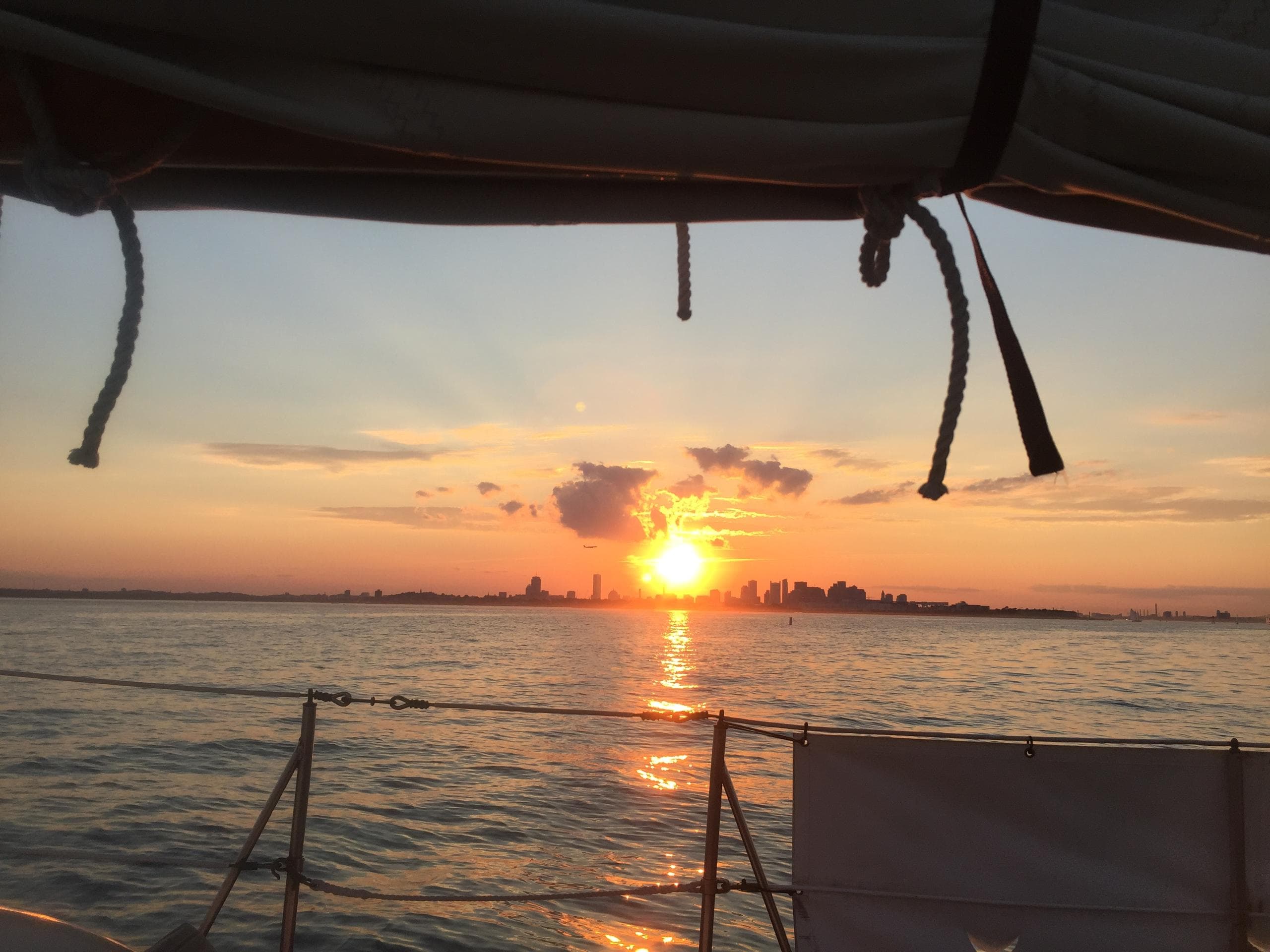 Sunset sailing with city skyline visible from boat deck
