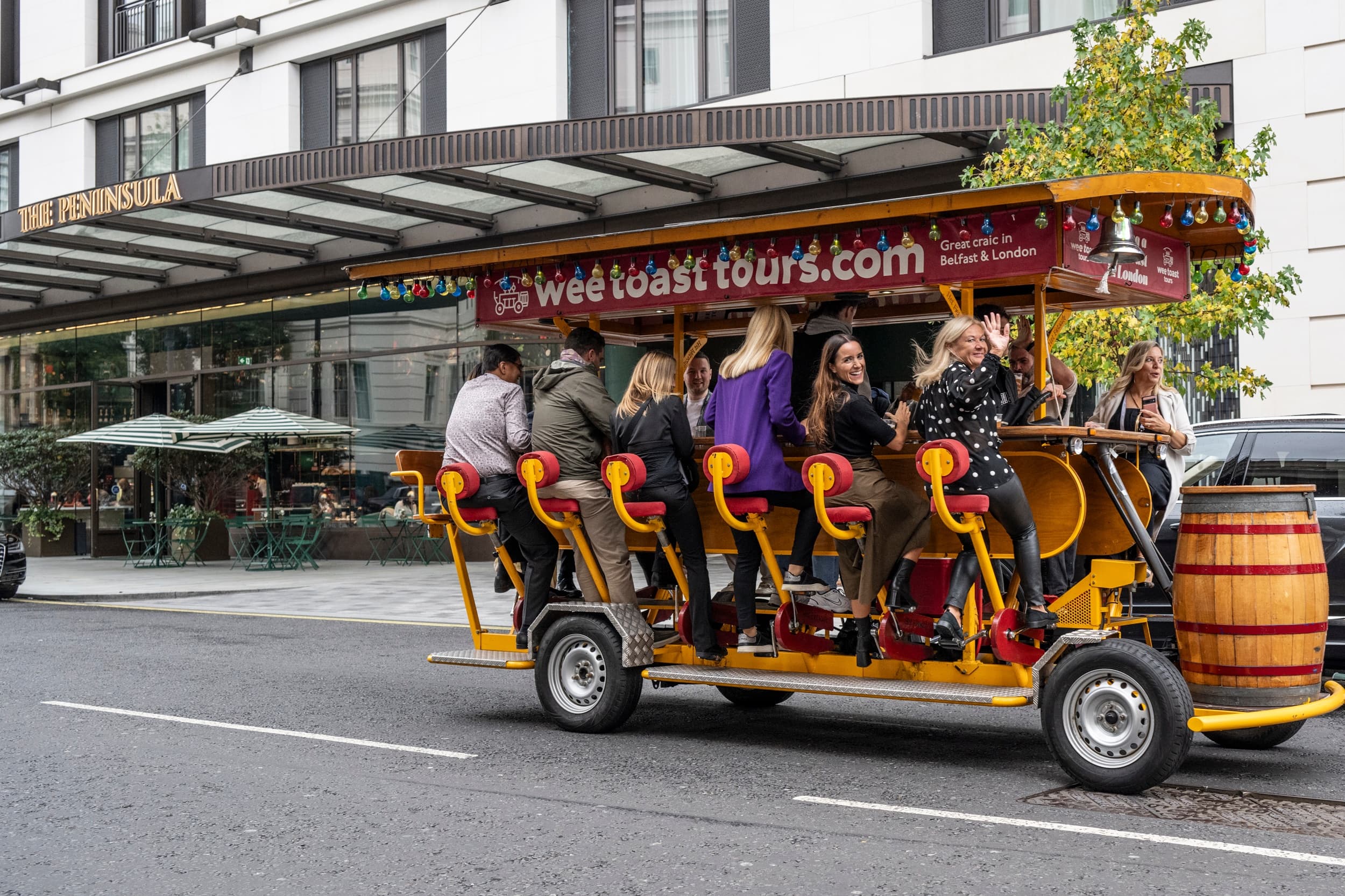 People riding a pedal pub on a busy urban street tour