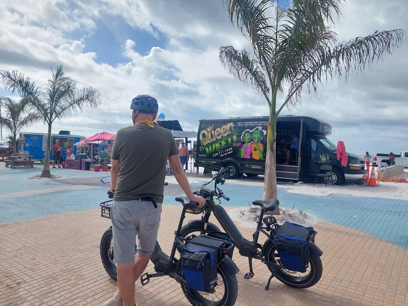 Couple with electric bikes on seaside boardwalk at beach