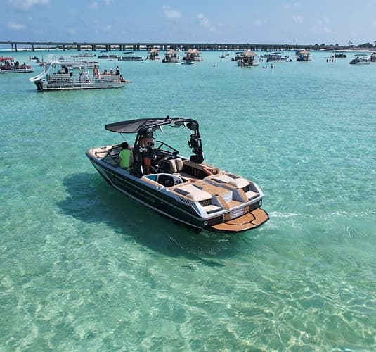Luxury motorboat anchored on turquoise sandbar in shallow sea