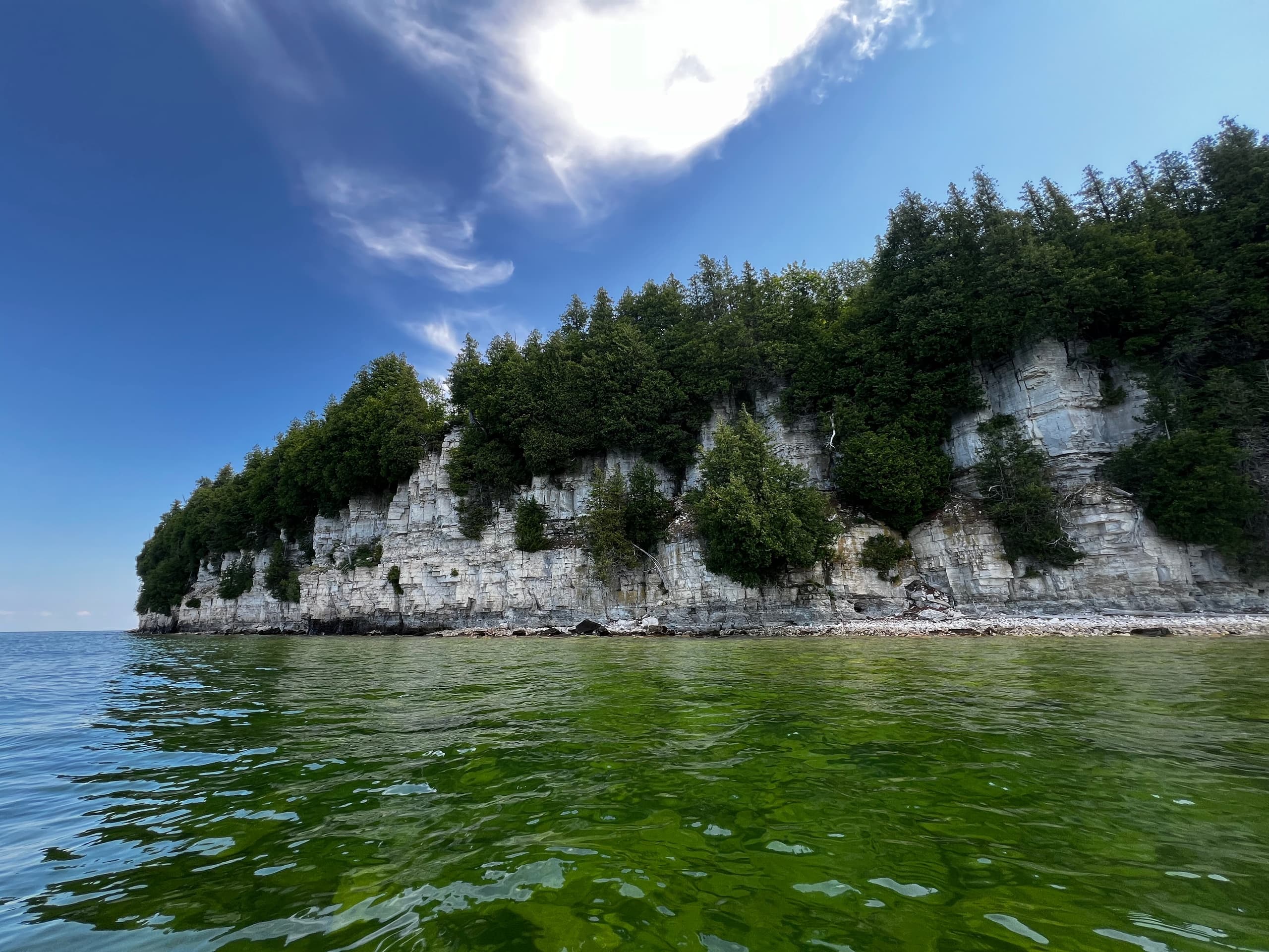 Cliffside limestone bluffs and kayak waters, scenic lakeshore view