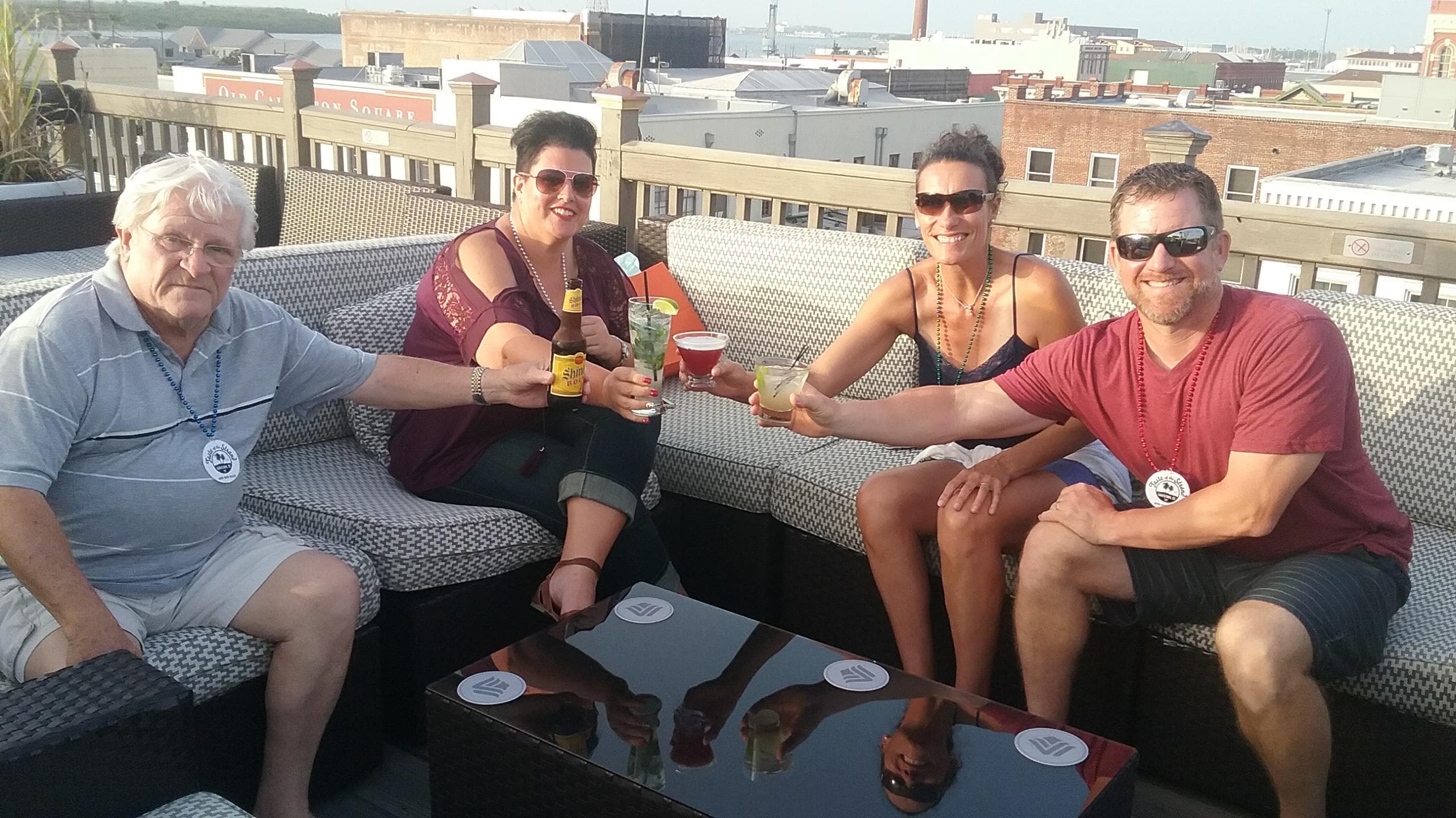 Group enjoying rooftop drinks with Galveston skyline and view
