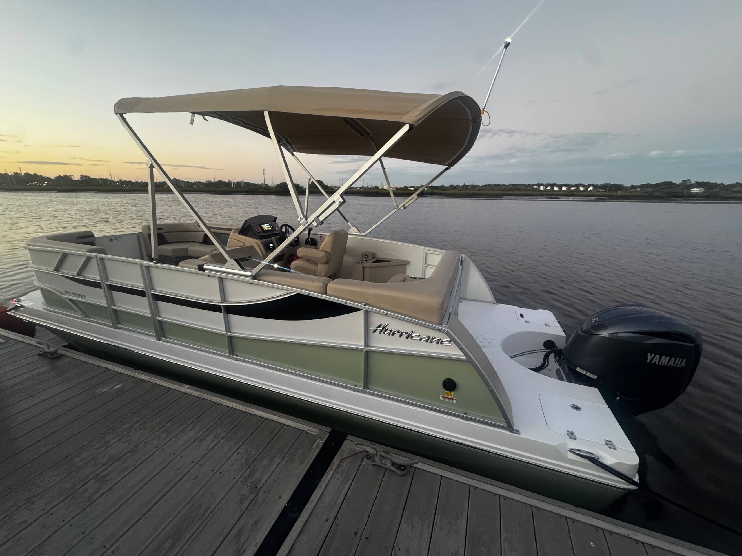 Luxury pontoon docked at sunset on calm waters, scenic harbor