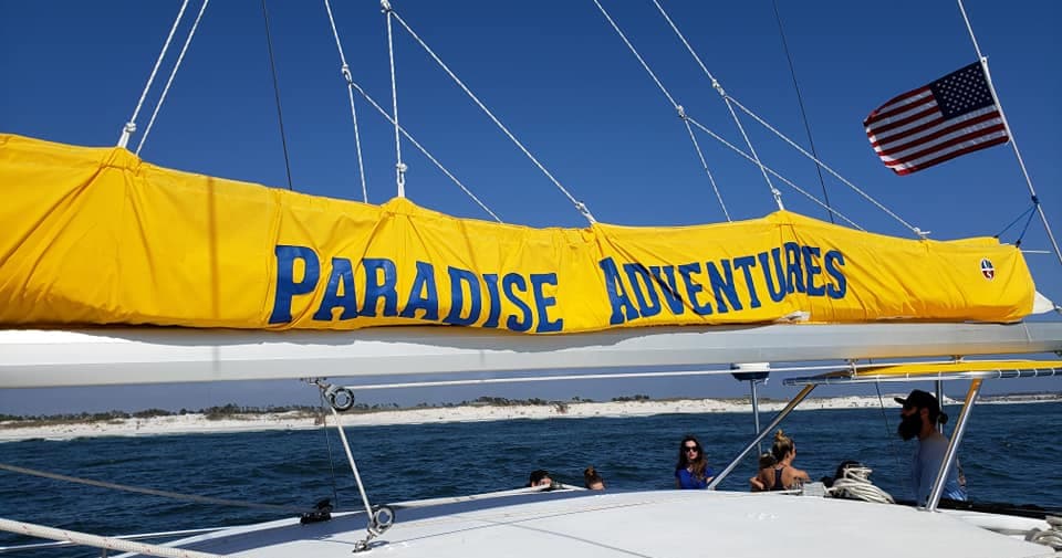 Sailboat with Paradise Adventures cover sailing on blue sea