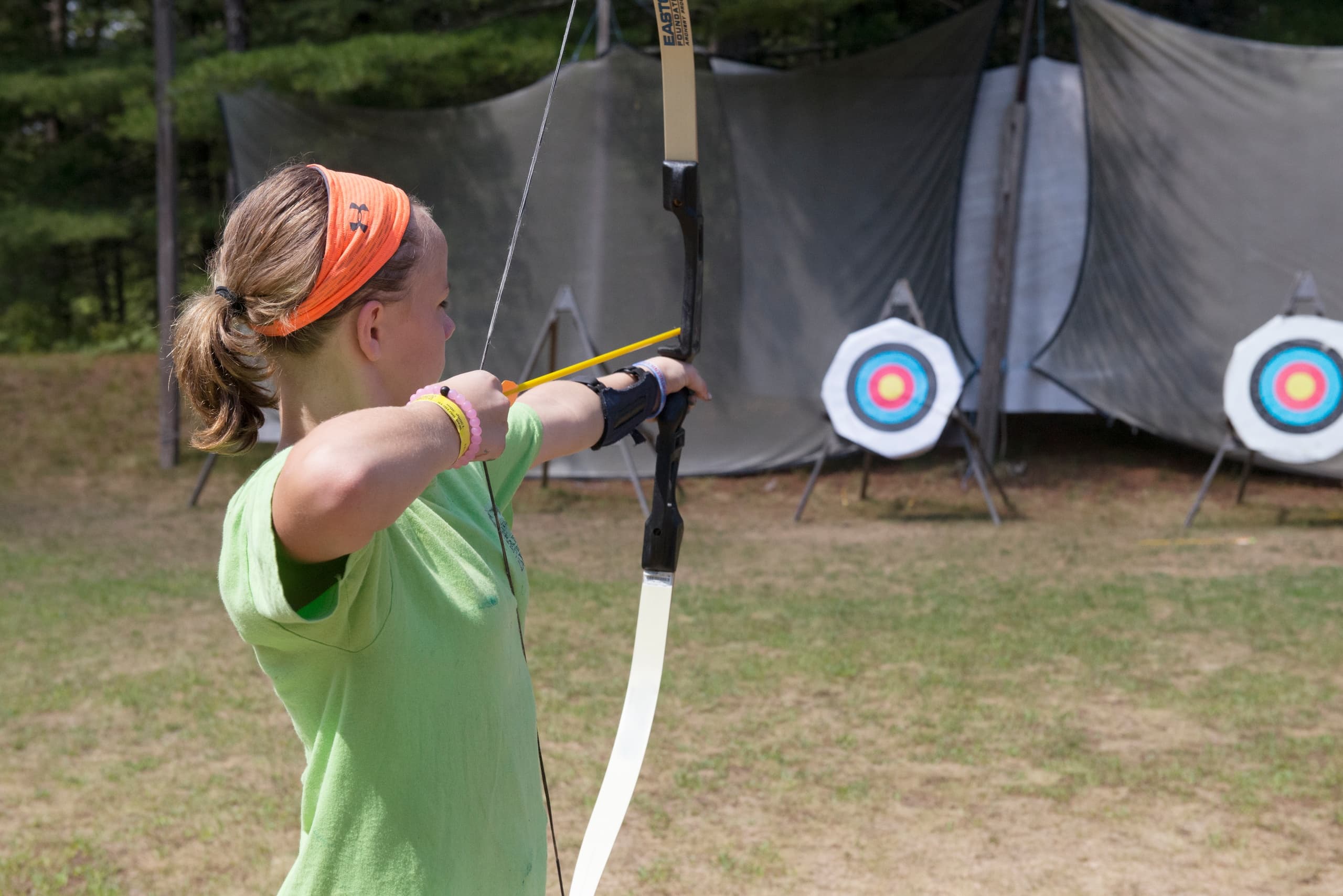 Archer practicing target shooting at outdoor archery range