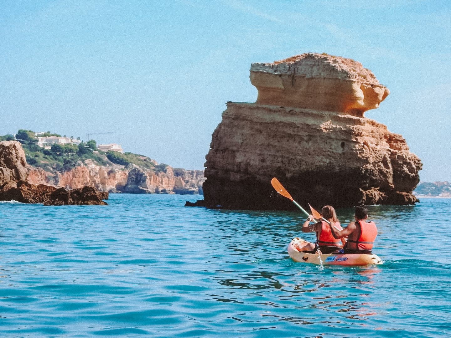 Kayakers paddling near dramatic sea stacks and rock formations