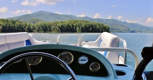 Pontoon boating on a scenic mountain lake, helm view