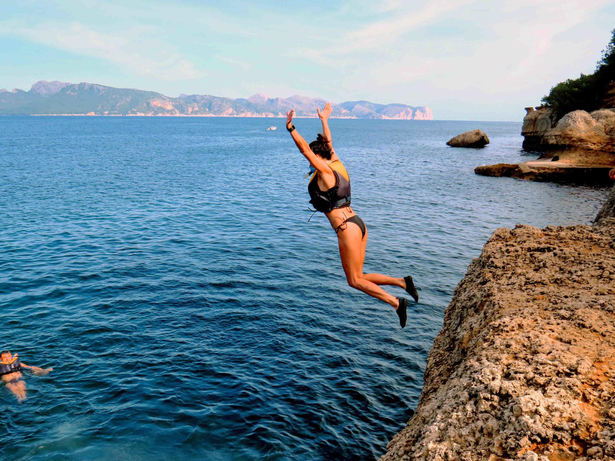 Cliff diver jumping into Mediterranean sea off Mallorca coast