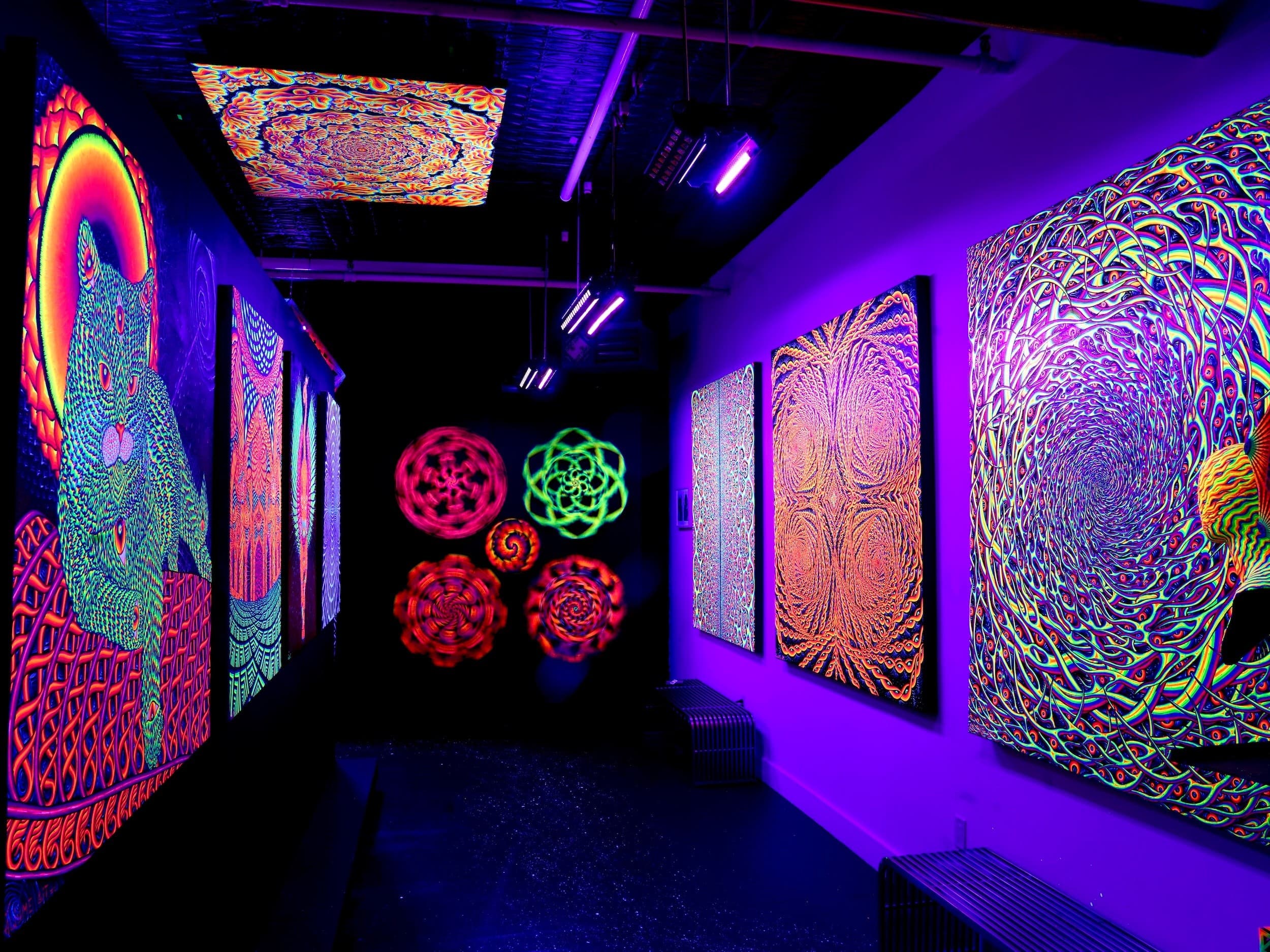 Blacklight tapestry and mandala installations in dark gallery hall