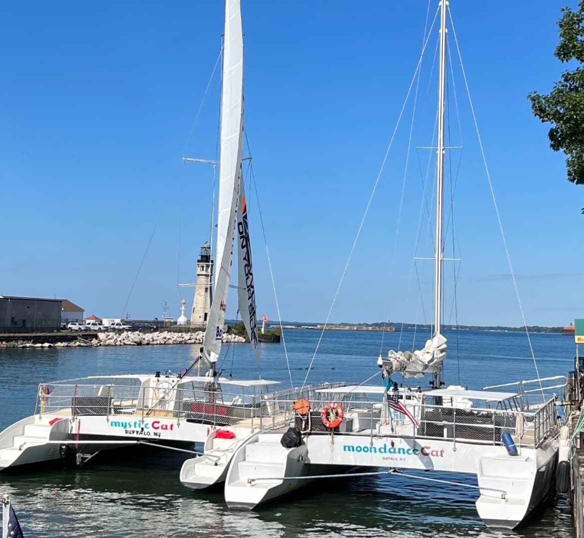 Moondance catamarans docked at marina with lighthouse on Lake Erie