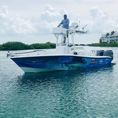 Sportfishing tower boat anchored near mangroves, calm turquoise sea