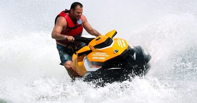 Man riding powerful jet ski cutting through ocean spray