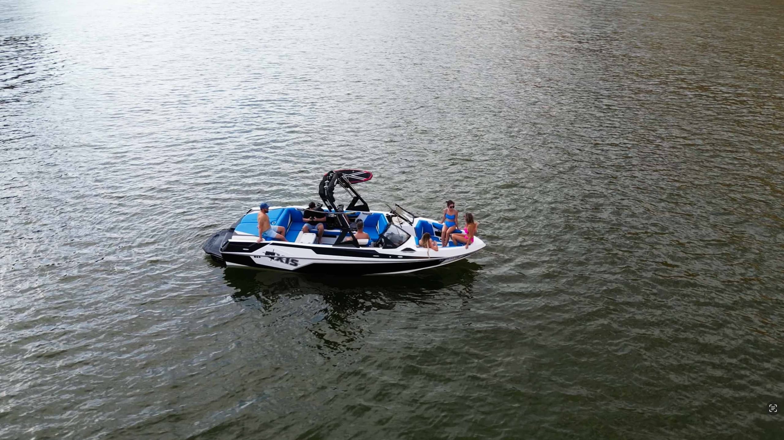 Motorboat with passengers navigating open water on sunny day